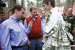 На Селигере доллары печатают на ксероксе. Дмитрию Медведеву и Сергею Иванову активисты объяснили, что таким образом борются за укрепление рубля. Загружается с сайта Ъ