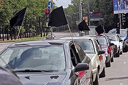 Единственное, что активисты успели сделать до приезда ОМОНа, это прикрепить к машинам черные флаги. Загружается с сайта Ъ