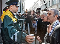 Путь в Центризбирком Гарри Каспарову (справа) и Эдуарду Лимонову (второй справа) преградили сотрудники ФСО. Загружается с сайта Ъ